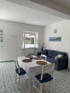 a living room with a table and a couch at Perla Bianca Holiday Home, Forio in Forio d'Ischia