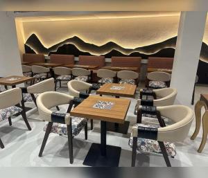 a restaurant with tables and chairs in a room at Hotel The Avoir Asansol in Āsansol