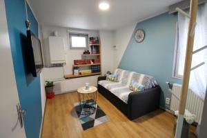 a living room with a couch and a tv at Gîte Le Parigney, proche de la voie bleue in Igney