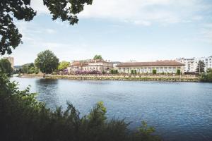 a view of a river with buildings in the background at Gîte Le Parigney, proche de la voie bleue in Igney