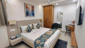 a hotel room with a bed and a television at Hotel Ivaan Homes opposite to Iskcon Temple East of Kailash New Delhi in New Delhi