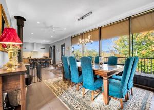 a dining room with a table and blue chairs at River Verse in Porepunkah