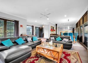 a living room with leather couches and a table at River Verse in Porepunkah