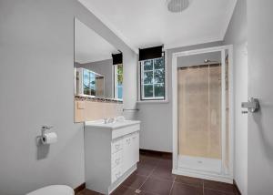 a white bathroom with a shower and a sink at River Verse in Porepunkah +21 photos