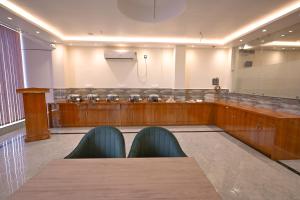 a conference room with a table and a stage at Madhuram Hotel in Ayodhya