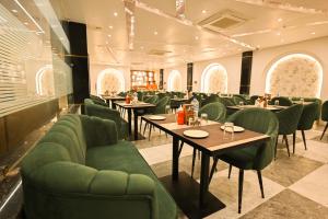a dining room with tables and green chairs at Madhuram Hotel in Ayodhya +15 photos