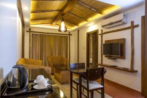 a living room with a table and a television at Hotel Sepoy Grande in Mysore
