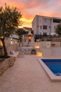 a villa with a swimming pool and a building at Villa Bella with pool in Novalja