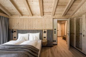 a bedroom with a large bed and wooden ceilings at Miraval NaturHotel in Badia +84 photos