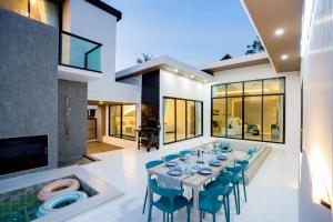 a dining room with a table and blue chairs at Cloud Pool Villa Pattaya in Na Jomtien