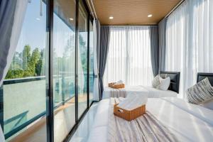 a bedroom with two beds and a large window at Cloud Pool Villa Pattaya in Na Jomtien +152 photos