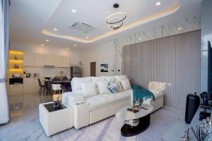 a living room with a white couch and a kitchen at Cloud Pool Villa Pattaya in Na Jomtien