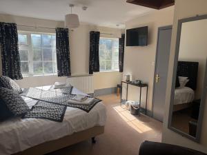 a bedroom with a bed and two windows at The Kings Arms in Cleobury Mortimer