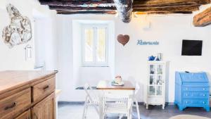 a kitchen with a table and chairs and a blue cabinet at Rio Alba Blue, Terre Marine in Riomaggiore +16 photos