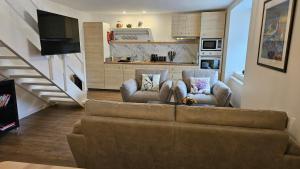 a living room with a couch and two chairs at Donmar Cottage in Skeabost