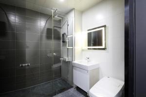 a bathroom with a toilet and a shower and a sink at 동대문 벨루스 호텔 in Seoul