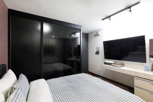 a bedroom with a bed and a flat screen tv at 동대문 벨루스 호텔 in Seoul