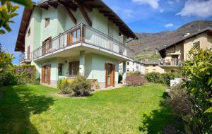 a large house with a green yard at Tra le Alpi - Holiday House in Tresivio