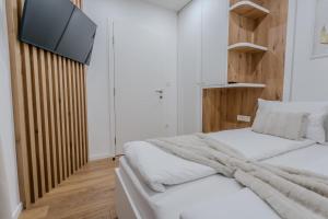 a bedroom with a bed and a tv on the wall at Mona Luxury Apartments - Free Garage Parking in Sarajevo