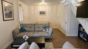 a living room with a couch and a table at Donmar Cottage in Skeabost