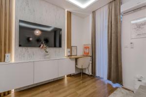 a living room with a television on a wall at Mona Luxury Apartments - Free Garage Parking in Sarajevo