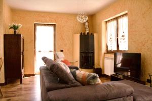a living room with a couch and a tv at Tra le Alpi - Holiday House in Tresivio