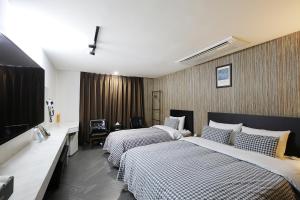 a hotel room with two beds and a television at 동대문 벨루스 호텔 in Seoul
