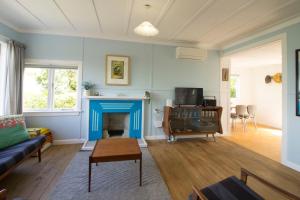 a living room with a couch and a fireplace at Classic bach near the beach in Oneroa