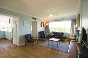 a living room with a couch and a table at Classic bach near the beach in Oneroa