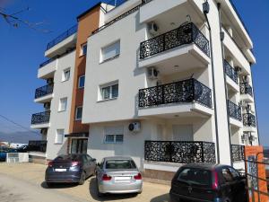 two cars parked in front of a building at Apartman Hedon in Vrnjačka Banja