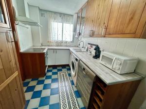 a small kitchen with a sink and a microwave at GATU City Puerto Preferente mayores 21 años y familias in El Puerto de Santa María