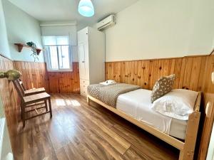 a bedroom with a bed and a wooden wall at GATU City Puerto Preferente mayores 21 años y familias in El Puerto de Santa María