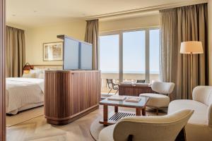 a hotel room with a bed and a television at Grand Hotel Huis ter Duin in Noordwijk aan Zee