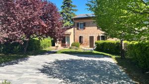 a brick house with a dog sitting in front of it at Cà Sabbioso in Dozza