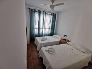 a room with three beds and a window at Son de Mar in La Isleta del Moro
