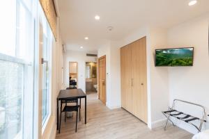 a living room with a table and a desk at NOX Kensington in London