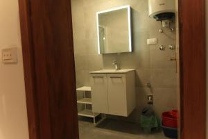 a bathroom with a sink and a mirror at Apartments Daidzic by El-Pi Tours in Njivice +19 photos