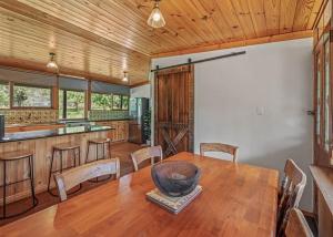 a dining room with a wooden table and a kitchen at Stonehaven in Freeburgh