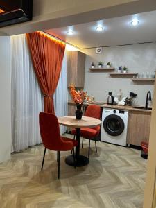 a kitchen with a table and chairs and a washing machine at Korkyt in Qyzylorda +4 photos
