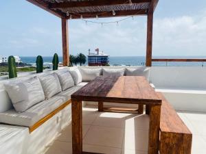a couch and a table on a balcony with the ocean at Casa Lucero in Arrieta