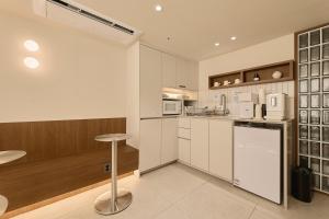 a kitchen with white cabinets and a bar stool at Hotel On You in Seoul