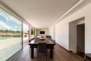 a dining room with a table and a large window at Villa Meti in Avola