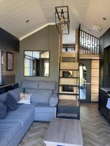 a living room with a blue couch and a staircase at Chapel Fields Holiday Park in Chapel Saint Leonards