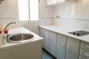 a white kitchen with a sink and a window at For You Rentals reina sofia apartment DF21 in Madrid