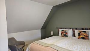 a bedroom with a bed and a chair at Donmar Cottage in Skeabost