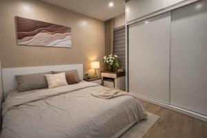 a bedroom with a bed and a sliding glass door at Luxury 1BR Apartment - Ocean Lake View - Vinhomes Ocean Park in Gia Lâm Pho