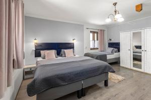 a bedroom with two beds and a mirror at Penzion Na Chalupě in Polička