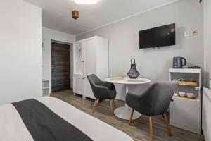 a bedroom with a bed and a table and chairs at Penzion Na Chalupě in Polička