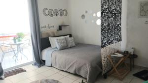 a bedroom with a bed and a balcony with a table at Welcome studio in Preveza