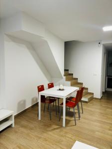 a dining room with a white table and red chairs at Casa Privada Benidorm Centro in Benidorm